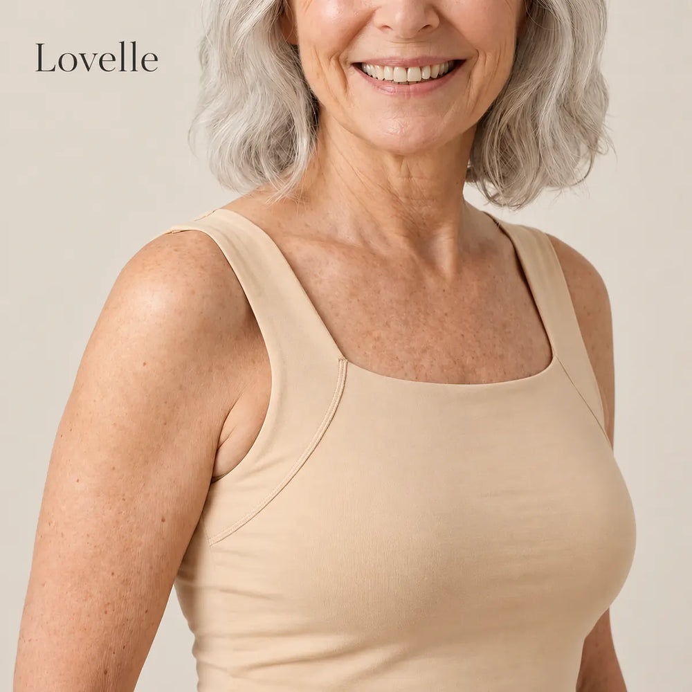 Hymyilevä hopeahiuksinen nainen Lovelle Ease -topissa sisäänrakennetuilla liiveillä, väri nude, neliön muotoinen pääntie ja leveät olkaimet